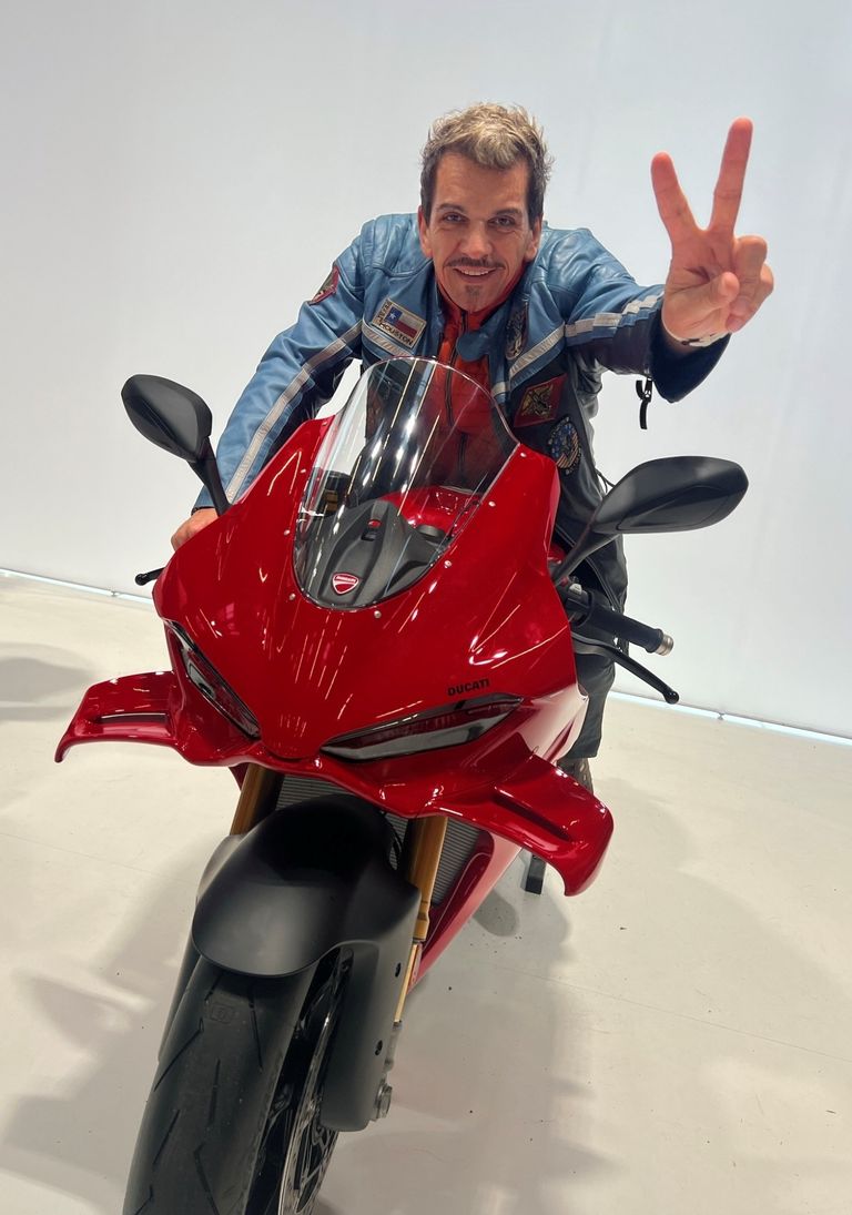 Fahrschulinhaber Andy sitzt auf einer roten Ducati Panigale und grüßt fröhlich